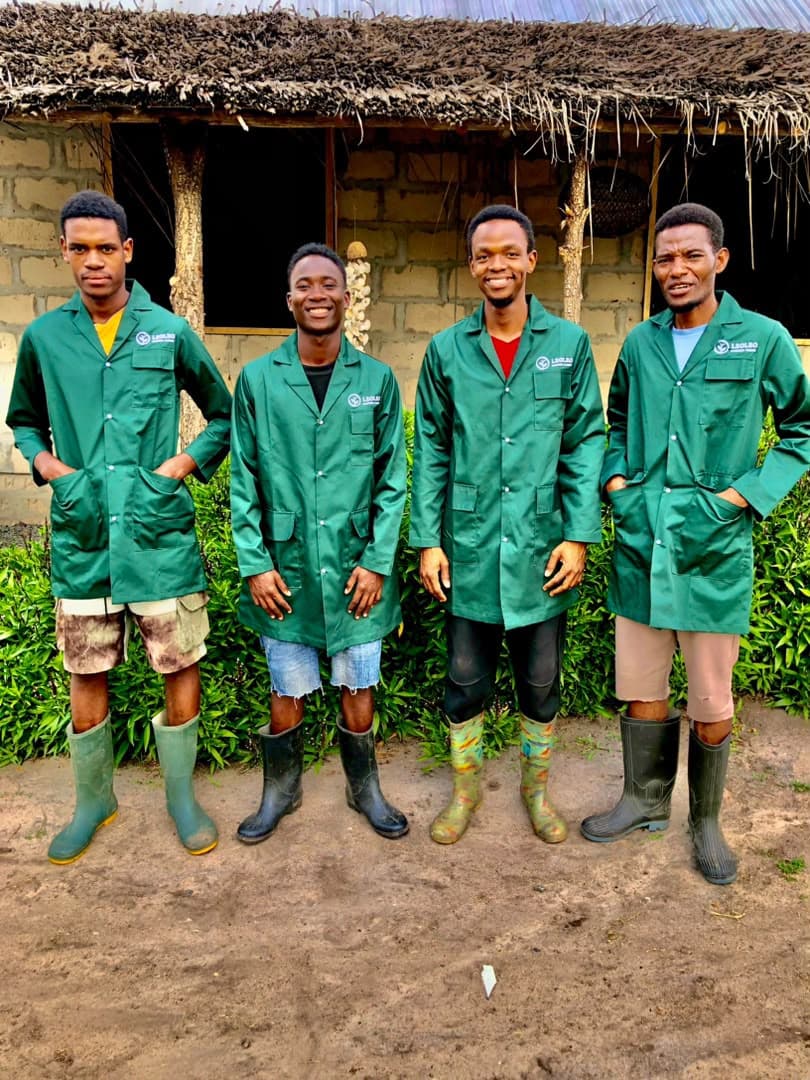 The Leoleo team outside the farm in their green work coats